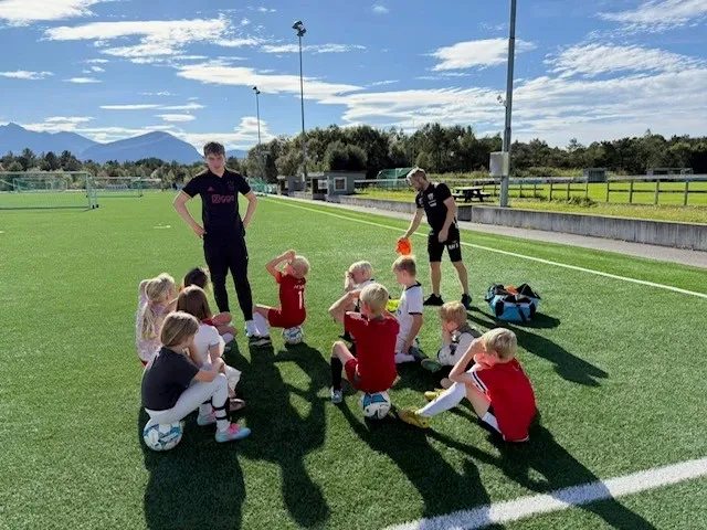 Barn og trenere på fotballbane